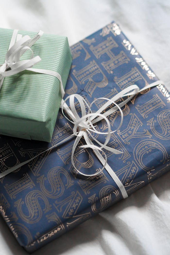 Close-up of elegantly wrapped gifts with decorative ribbons on a bedspread. Ideal for celebrations.
