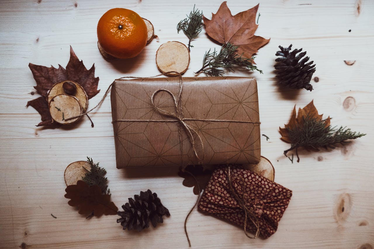 category-04 A rustic styled gift wrap with natural autumn elements like pine cones and leaves on a wooden surface.